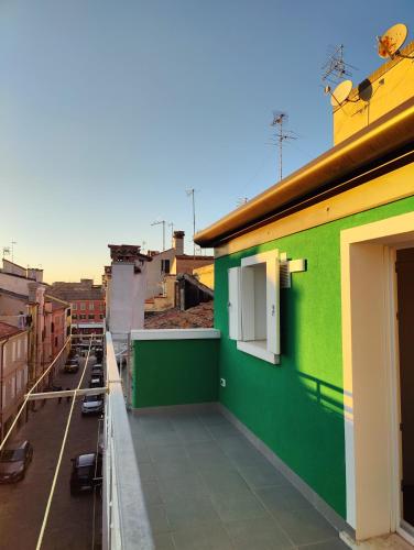 a green building with a window on a balcony at Parsifal House in Chioggia