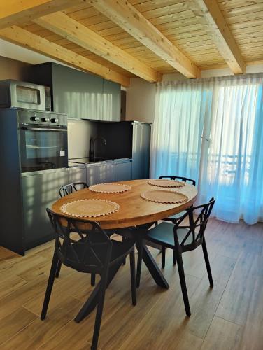 a dining room table with chairs and a kitchen at Parsifal House in Chioggia
