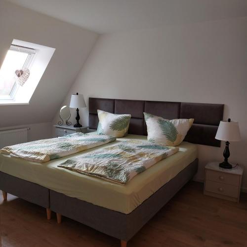 a bedroom with a large bed with two lamps at FeWo Dreiseitenblick Komfort mit 2 Schlafzimmern in Bad Doberan