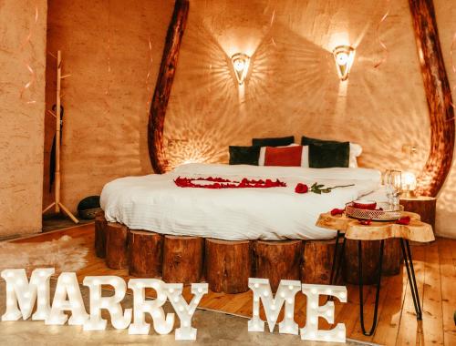 a bed in a room with a marry me sign at Панорама хаус Лещен и еко къщи Дървена и Землянка in Leshten