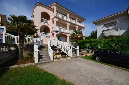 a large pink house with a car parked in front of it at Room in Lopar with Balcony, WIFI 4620-95 in Lopar
