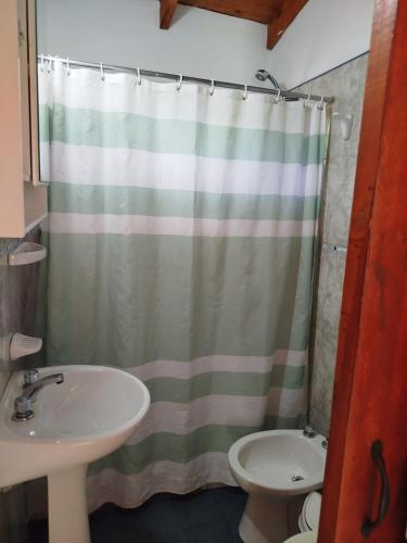 a bathroom with a shower curtain and a sink at Cabañas del Puente - Rio Grande San Luis in La Bajada