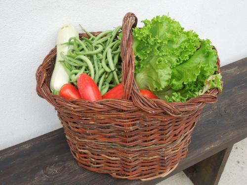 a basket filled with vegetables on a wooden table at Casa Rovelli in Alfiano Natta