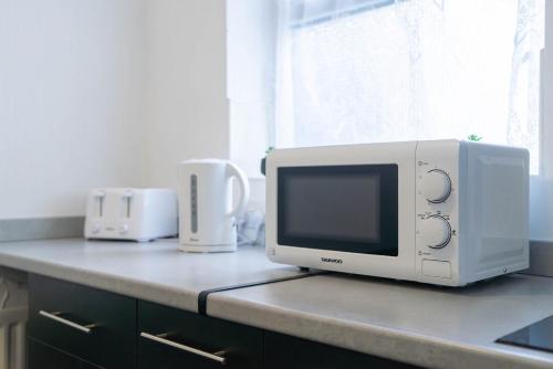a microwave sitting on top of a kitchen counter at Carlisle Comfort Terrace in Carlisle