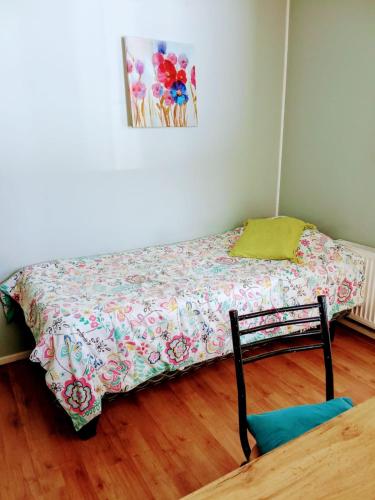 a small bed in a room with a painting on the wall at Residencial HITAPUHAN in Punta Arenas
