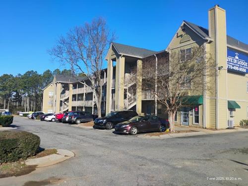 a parking lot with cars parked in front of a building at Live In Lodge Marietta in Marietta