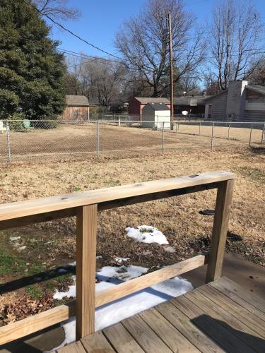 a wooden bench in front of a baseball field at Entire House in the Heart of NW AR with Office Space in Springdale