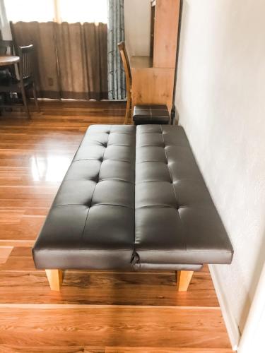 a black couch sitting in a room with a chair at Entire House in the Heart of NW AR with Office Space in Springdale