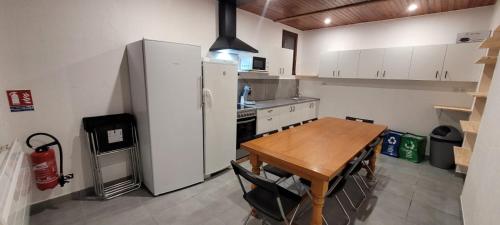 une cuisine avec une table en bois et un réfrigérateur dans l'établissement Chez Marcel, à Échenans