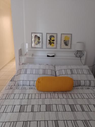 a bedroom with a bed with a yellow pillow on it at Lugar encantado - Apartamento in Brasília