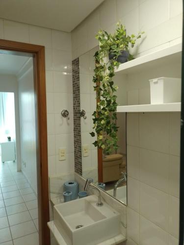 a bathroom with a sink and a mirror at Lugar encantado - Apartamento in Brasília