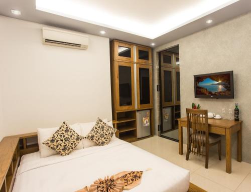 a bedroom with a bed and a table and a desk at Valentine Hotel in Ho Chi Minh City
