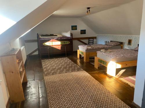 a attic room with two beds and two tables at Viscri 143 in Viscri