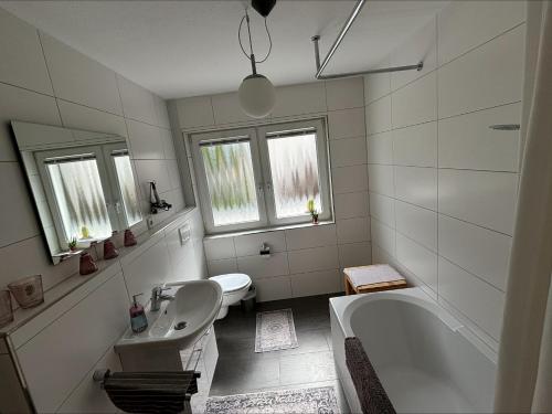 a white bathroom with a tub and a sink at GartenOase in der Universitätsstadt 3 Zimmer Haus mit Parkplatz in Erlangen
