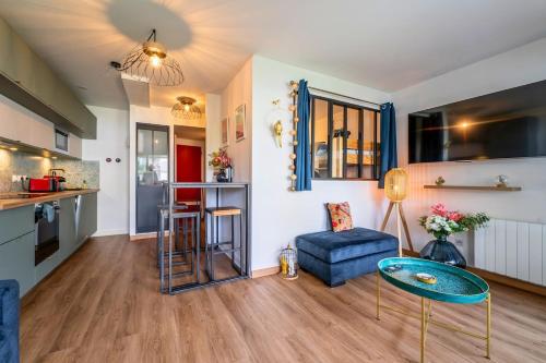 a living room with a blue couch and a table at La perle du Bassin - Plage Pereire - Arcachon in Arcachon