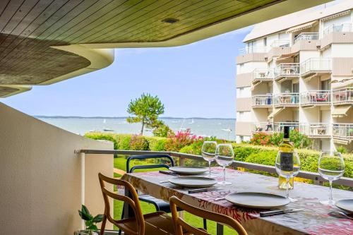 a table with wine glasses on the balcony of a condo at La perle du Bassin - Plage Pereire - Arcachon in Arcachon