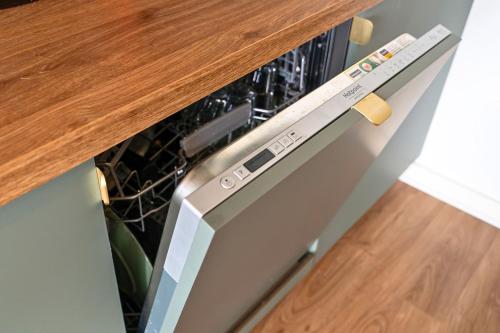 a dishwasher in a kitchen with a wooden counter top at La perle du Bassin - Plage Pereire - Arcachon in Arcachon