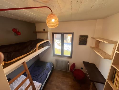 une chambre avec deux lits superposés et une fenêtre dans l'établissement Au Soleil, à Séez