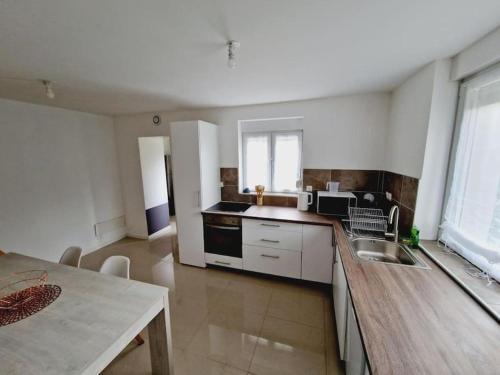 une cuisine avec un évier et une table à l'intérieur dans l'établissement Maison calme et toute équipée avec jardin, à Maing
