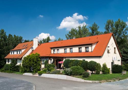 una casa con tetto arancione su una strada di Hotel-Restaurant Elsterblick a Elsteraue