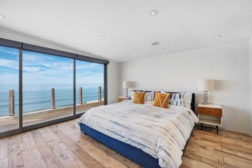 a bedroom with a large bed with a view of the ocean at Hi-Tech Hideaway - Modern & Ocean Front! in Solana Beach