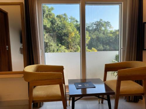 a room with two chairs and a table and a window at Rootz in Dehradun