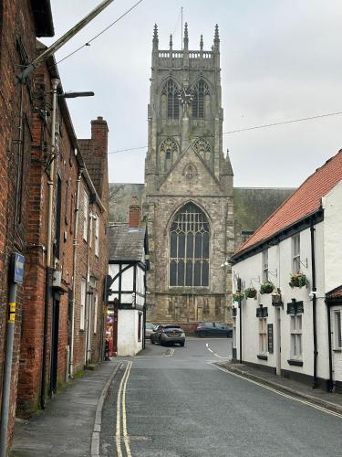 an old church with a clock tower in a street at Charming Town Retreat in Hedon