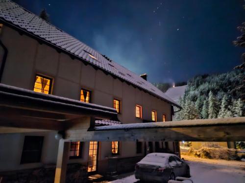 a house with a car parked in front of it at night at Apartmaji Koželj in Ribnica na Pohorju