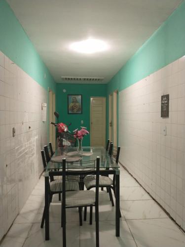a dining room with a table and chairs and green walls at Casa para o Período da COP30 in Barcarena