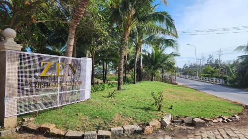a sign on the side of a road with palm trees at ZEN Resort - Villa beach- Garden in Xóm Tram