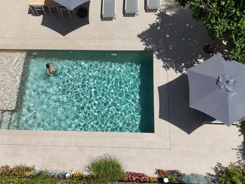 an overhead view of a person in a swimming pool with an umbrella at Casa Hermanos by Costabravaway in Calonge