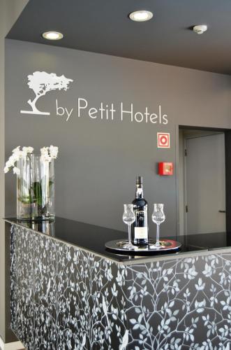 a bar with wine glasses and a sign that reads by petit hotels at Madeira Bright Star by Petit Hotels in Funchal