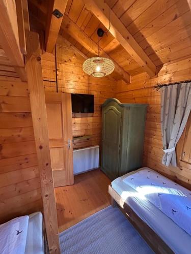 a room with a bed in a wooden room at Blockhaus Holzzeit im Bayerischen Wald in Stamsried