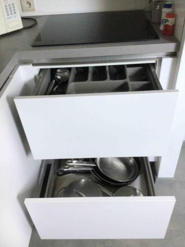 an open drawer in a kitchen with pots and pans at Cosy attic apartment, terrace, 1 bedroom south in Opdorp