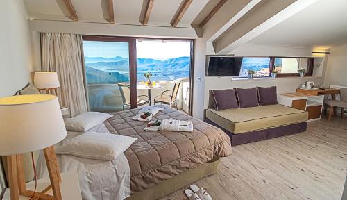 a bedroom with a bed and a large window at Fedriades Delphi Hotel in Delfoi