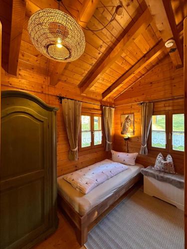 a bedroom with a bed in a wooden cabin at Blockhaus Holzzeit im Bayerischen Wald in Stamsried