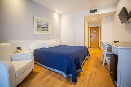 Un dormitorio con una cama, un sofá y un televisor. en Hotel Auditorio Santiago & Spa, en Lugo