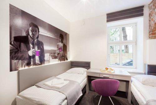 a room with two beds and a purple chair at Pokoje Cinema in Poznań