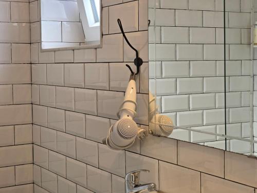 - une salle de bains avec 2 brosses à cheveux sur un miroir dans l'établissement Casa Sebastião, à Faro