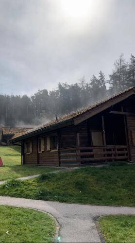 a log cabin with a porch on a field at Blockhaus Holzzeit im Bayerischen Wald in Stamsried