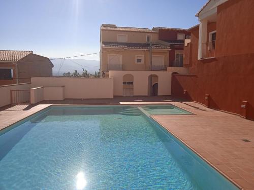 a swimming pool in front of a house at Apartamento entre playa y montaña in Sanet y Negrals