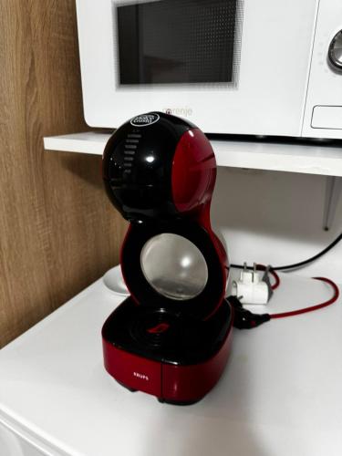 a red hair dryer sitting on top of a counter at Apartman Ana in Bjelovar