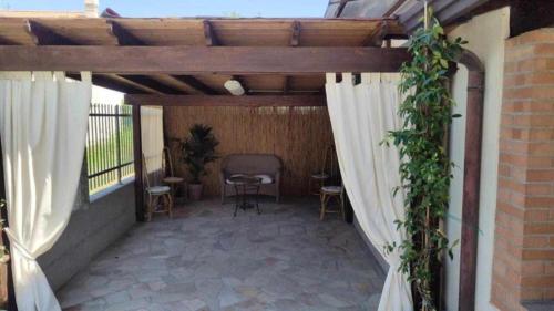 a patio with white curtains and a table and chairs at Traghetto vecchio house in Cavallino-Treporti