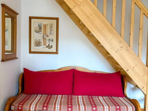 - un lit avec des oreillers rouges dans une chambre avec un escalier dans l'établissement Appartement à Notre-Dame-de-Bellecombe, 2 chambres, 6 pers, cuisine équipée - FR-1-807-59, à Notre-Dame-de-Bellecombe