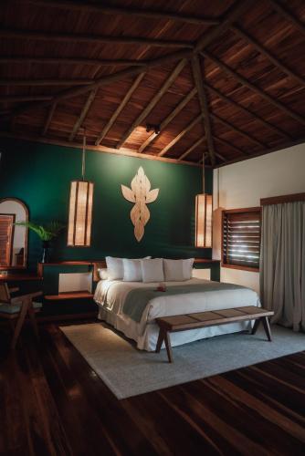 a bedroom with a large bed and a green wall at Vila Selvagem Hotel Contemporaneo in Fortim