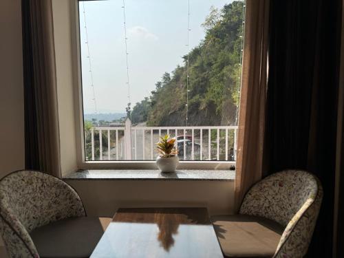 a table and two chairs in front of a window at Rootz in Dehradun