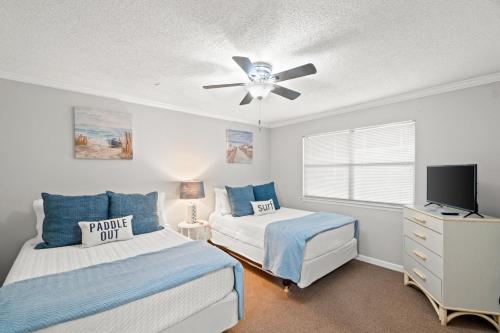 a bedroom with two beds and a ceiling fan at Edgewater Golf Villa 1210 in Panama City Beach