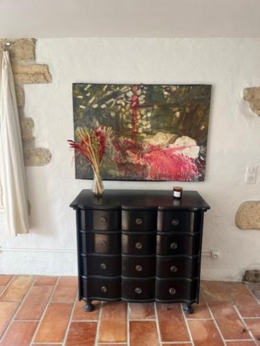 a painting on the wall above a black dresser at Terralha in Meynes
