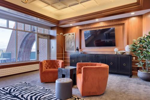 a living room with two chairs and a tv at The Executive Suites and Events in Ephrata