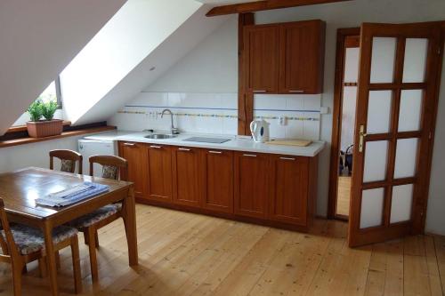 a kitchen with wooden cabinets and a table and a sink at Country House with four apartments in Drahov